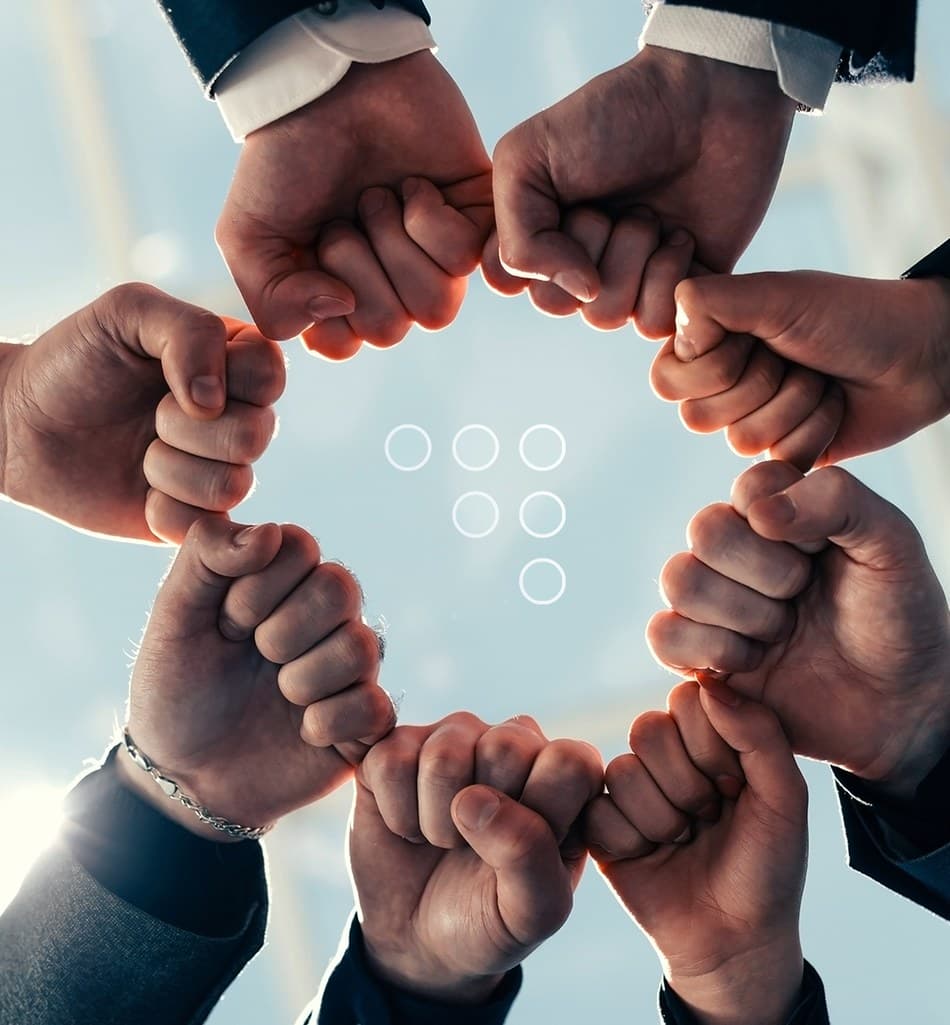 Team members forming a fist-bump circle symbolizing unity and partnership