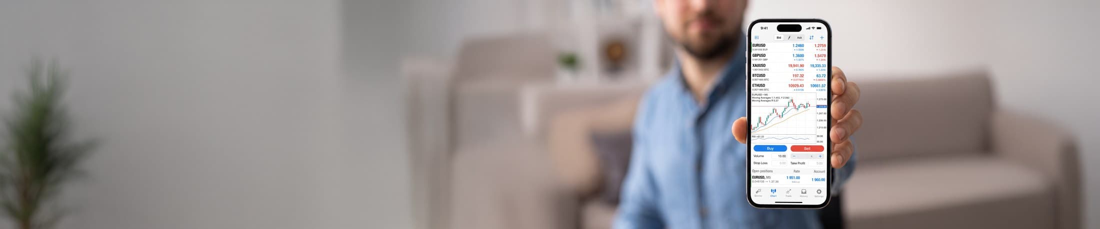 Trader holding a phone displaying the KIRA trading platform